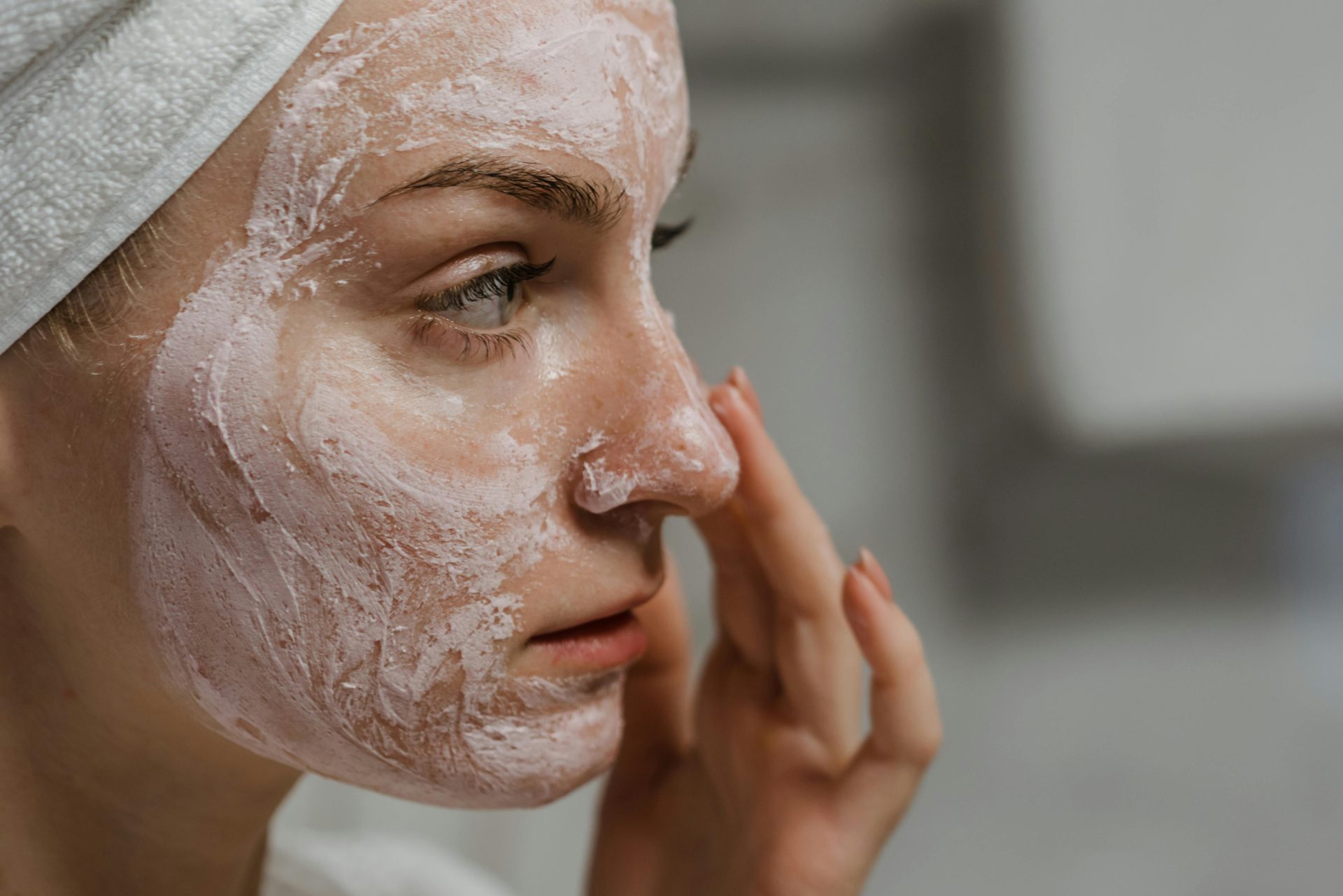 Gros plan sur une femme appliquant une crème pour le visage dans le cadre de sa routine de soins, pour une peau plus saine.